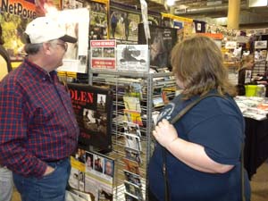 People stop by to listen to TV video and pick up postcard information and brochures. OEAendofboothviewersDSCN4186.jpg